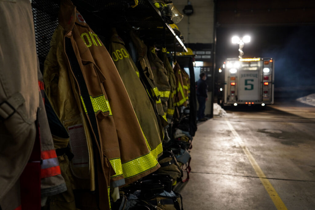 2021-03-10-k-coooper-fire-company Firefighter coats are lined up, with an ambulance in the background