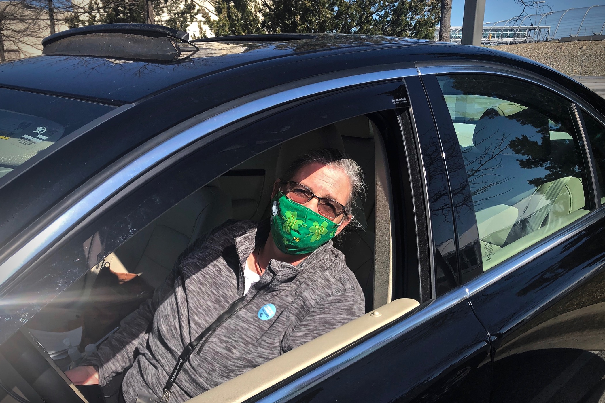 Susan Smith wears a face mask while sitting inside her car