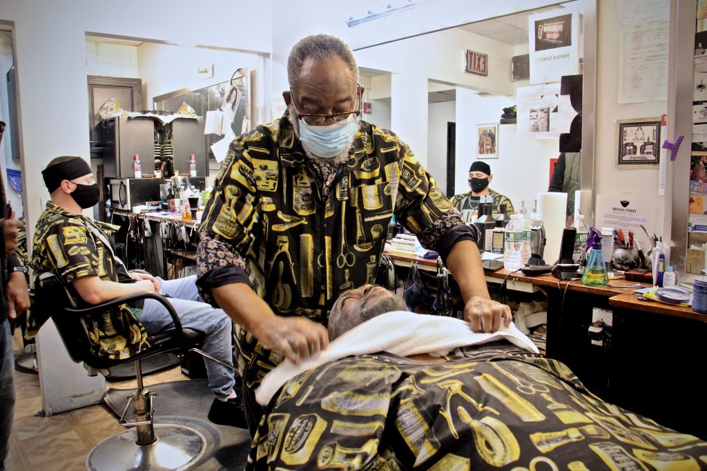 2021 03 19-e lee-leroy robinson-philadelphia lancaster avenue-business corridor Leroy Robinson Jr. tends to a customer at Leroy's Barbershop on Lancaster Avenue. (Emma Lee/WHYY)