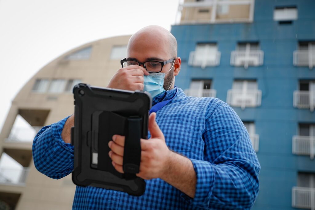 AP20226561975456 Joseph Ortiz, a contact tracer with New York City's Health + Hospitals battling the coronavirus pandemic, uses his tablet to gather information as he heads to a potential patient's home Thursday, Aug. 6, 2020, in New York. The city has hired more than 3,000 tracers and the city says it's now meeting its goal of reaching about 90% of all newly diagnosed people and completing interviews with 75%. (AP Photo/John Minchillo)