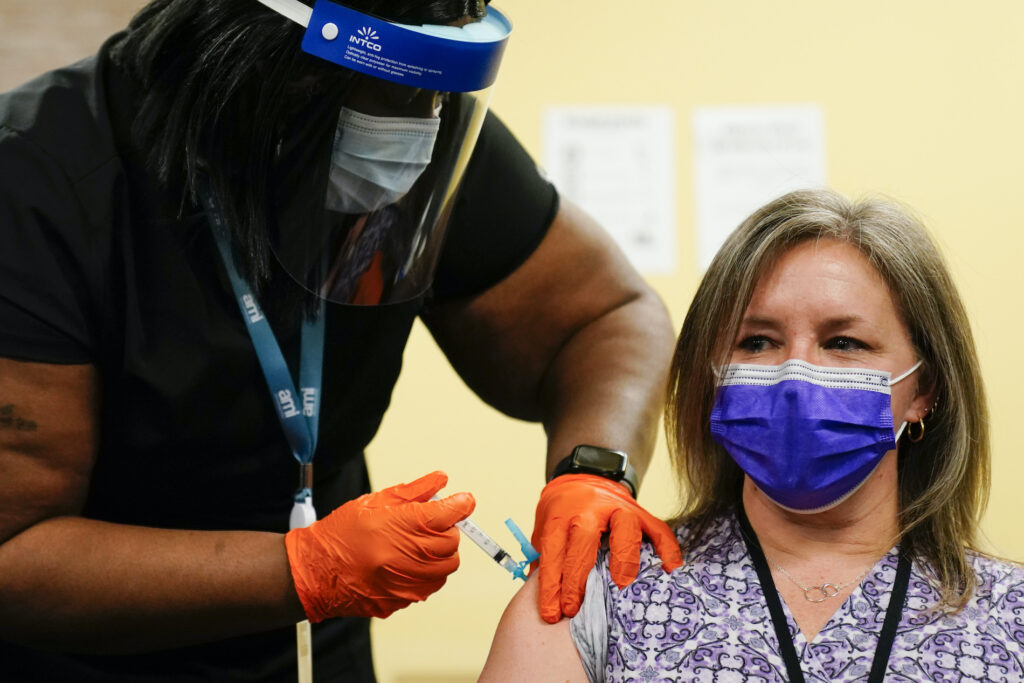Nurse Monique Bourgeois, left, administers the Johnson & Johnson COVID-19 vaccine to educator Diane Kay at a vaccination site set up setup for teachers and school staff at the Berks County Intermediate Unit in Reading, Pa., Monday, March 15, 2021. (AP Photo/Matt Rourke)
