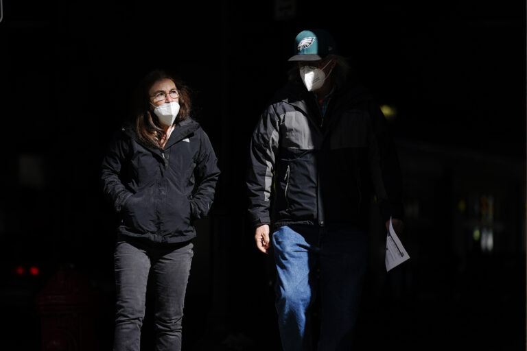 People wearing face masks as a precaution against the coronavirus walk in Philadelphia