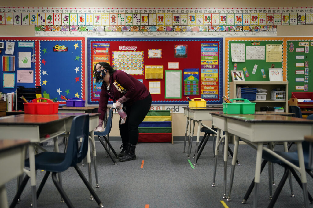 Vegas Schools Reopening Tia Baker cleans a desk in a classroom