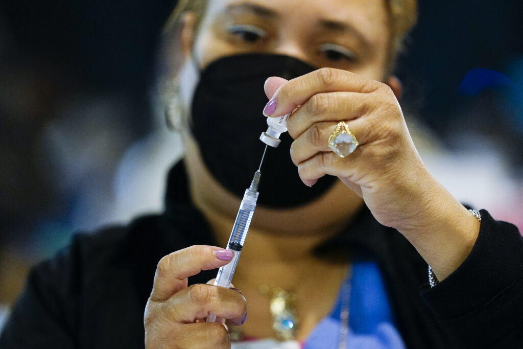 AP_coronavirus_vaccine_PA_031821_01 A health worker prepares a dose of the Pfizer COVID-19 vaccine