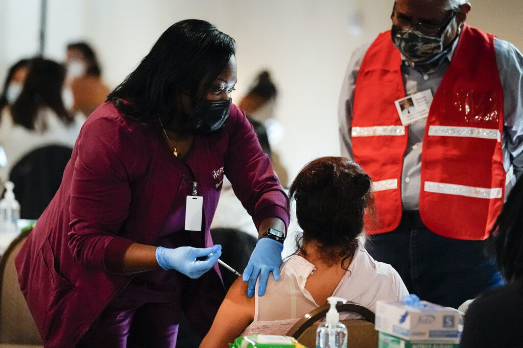 AP_coronavirus_vaccine_PA_031821_02 A health worker administers a dose of a Pfizer COVID-19 vaccine