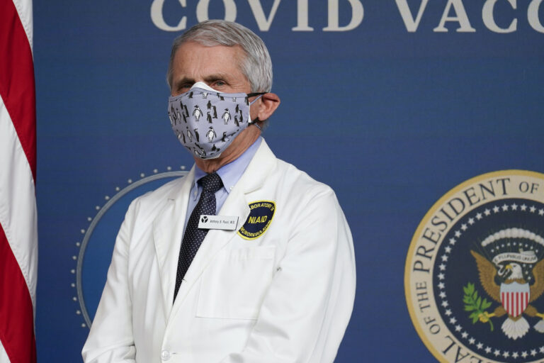 Dr. Anthony Fauci wears a face mask and white coat at a COVID-19 briefing