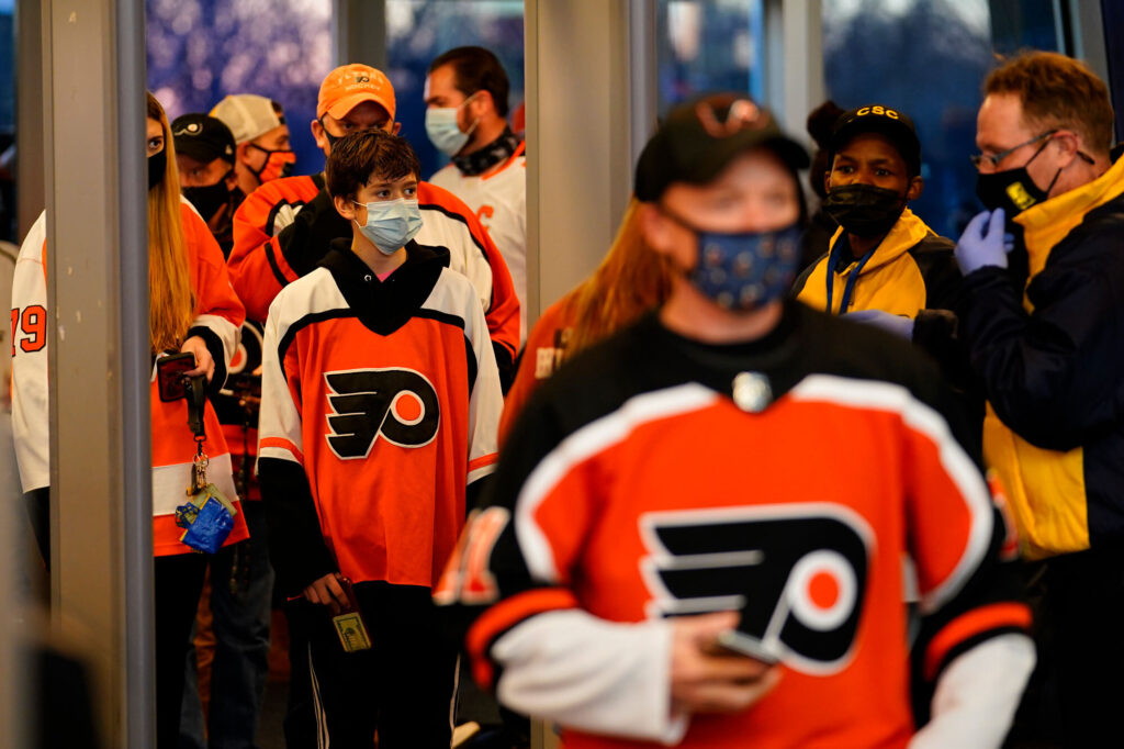 Capitals Flyers Hockey Fans wearing masks walk through security at the Wells Fargo Center