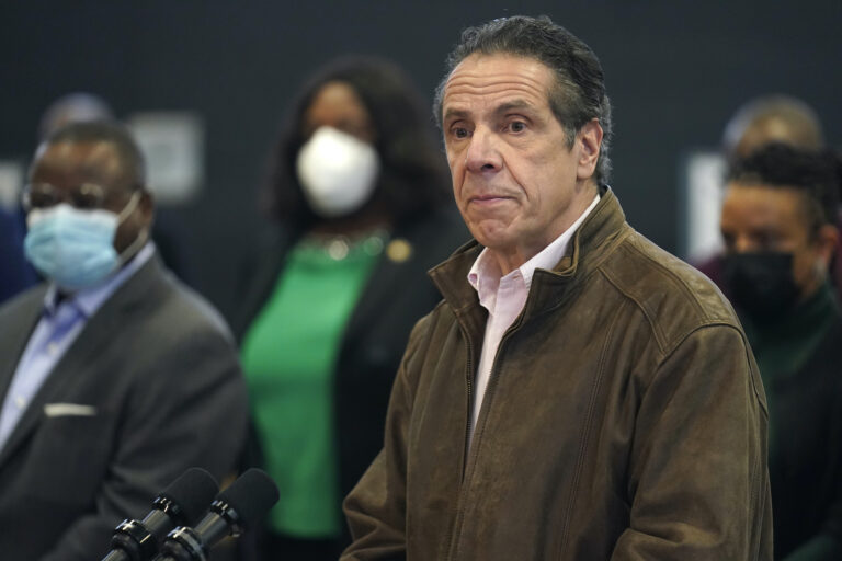 New York Gov. Andrew Cuomo, right, listens to a reporter's question during a news conference