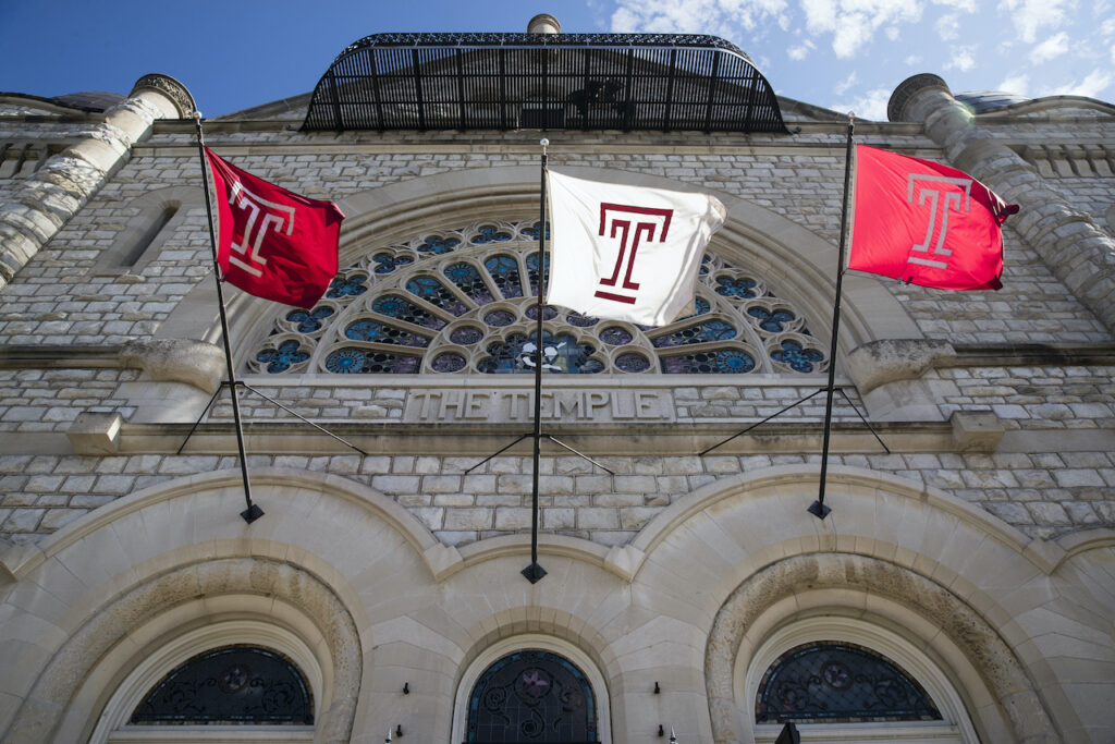 Pennsylvania Daily Life Flags wave in the wind from a building on Temple University's campus