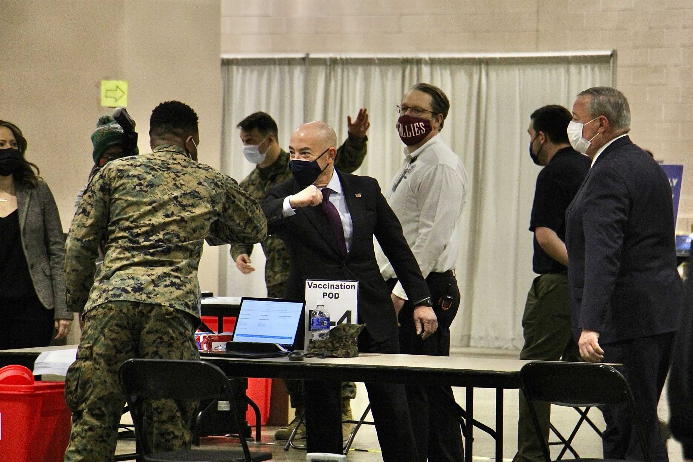 Department of Homeland Security Secretary Alejandro Mayorkas elbow bumps a National Guard member during a tour of FEMA’s community vaccination site at the Pennsylvania Convention Center