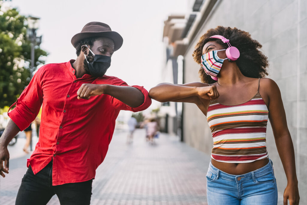 bigstock-African-Friends-Wearing-Face-P-396994544-web Two friends greeting each other with elbow bumps during the COVID-19 pandemic