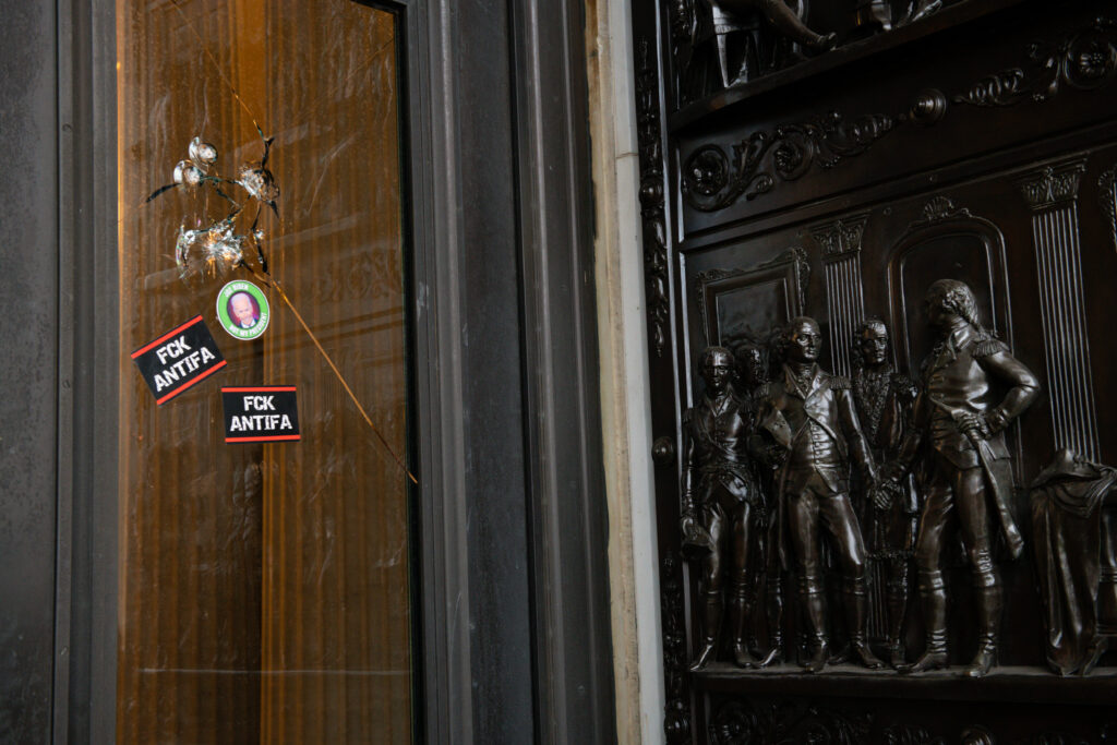 Stickers reading “Fck Antifa” are stuck on a broken window at the U.S. Capitol after the building was breached by rioters on Jan. 6. Stickers reading