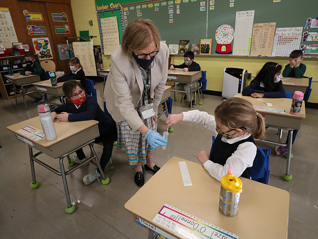 Pool Testing In Schools A student gives her coronavirus swab to Helenann Civian