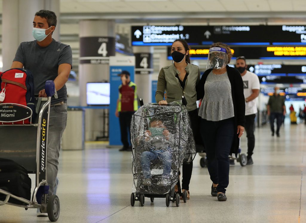 pandemic-end-01_custom-1a2a3939be301869bcebdc98fdf08cfa37588b67-s1600-c85 People travel through an airport with luggage