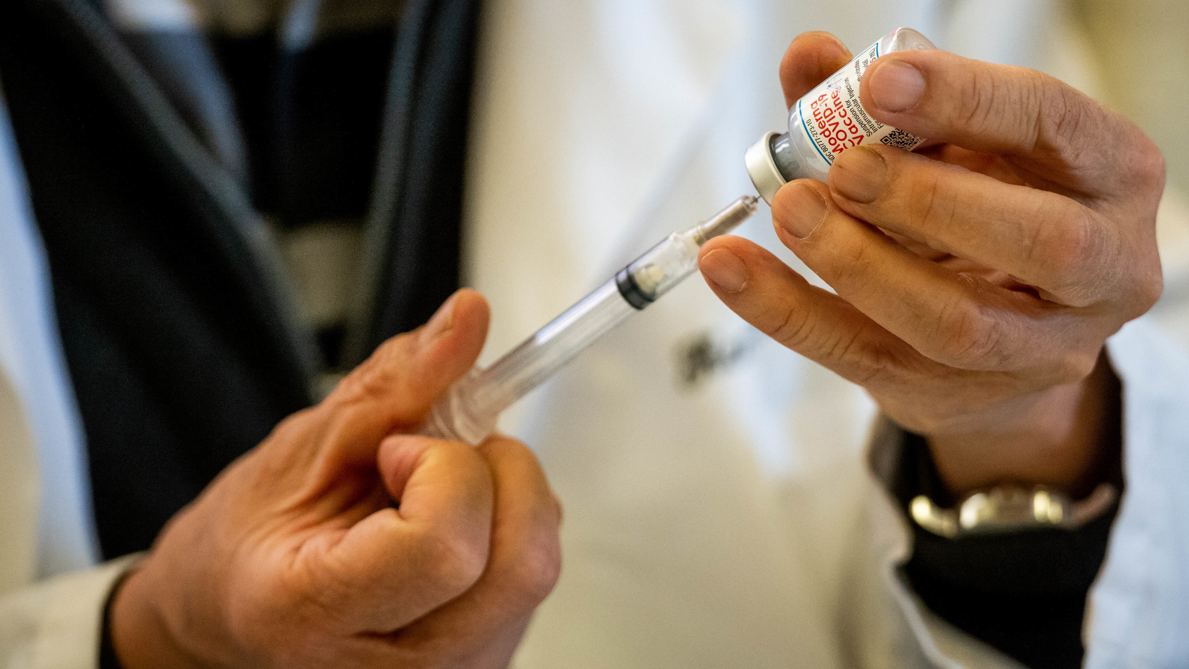 A health worker fills syringes with the Moderna COVID-19 vaccine
