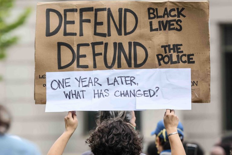 A protester holds up a sign during a We Still Can’t Breathe March