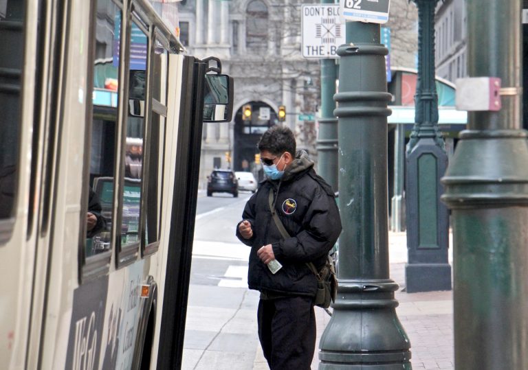 A passenger boards a SEPTA bus on Market Street near City Hall. (Emma Lee/WHYY)