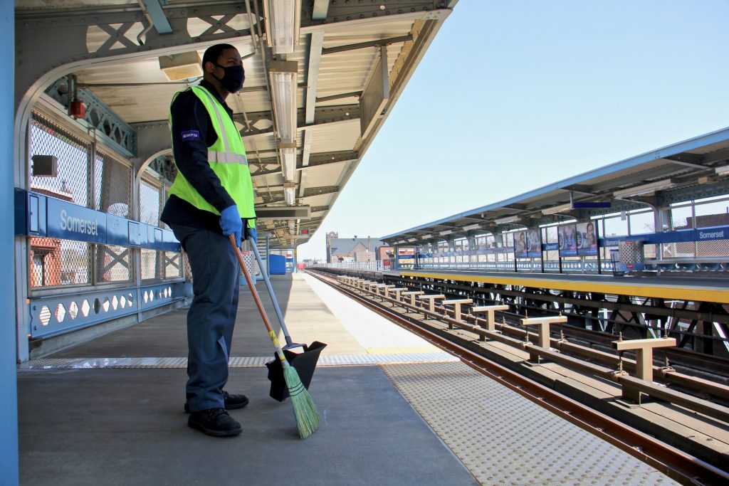 2021 04 05-e lee-philadelphia somerset station septa market frankford-sweeper A SEPTA employee has a broom in hand at an outdoor station on the Market-Frankford line.