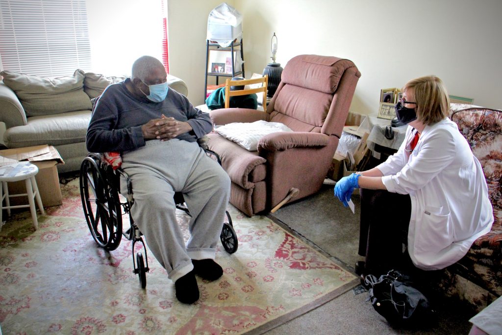 2021 04 09-e lee-turner pittman rebecca bryan-camden nj westfield towers-county vaccine clinic wait Rebecca Bryan of Rutgers School of Nursing sits with 86-year-old Turner Pittman