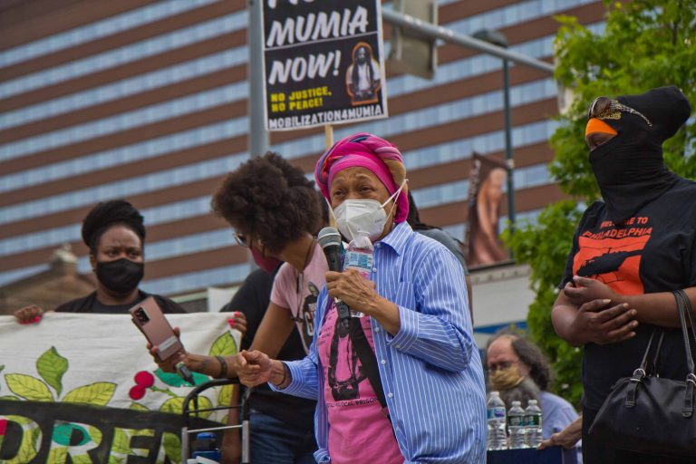 Pam Africa described police abuse her family experienced at a protest outside the Penn Museum on April 28, 2021, over the museum’s mistreatment of the remains of children Tree and Delisha Africa who were killed when Philadelphia police dropped explosives on MOVE's headquarters in 1985. (Kimberly Paynter/WHYY)