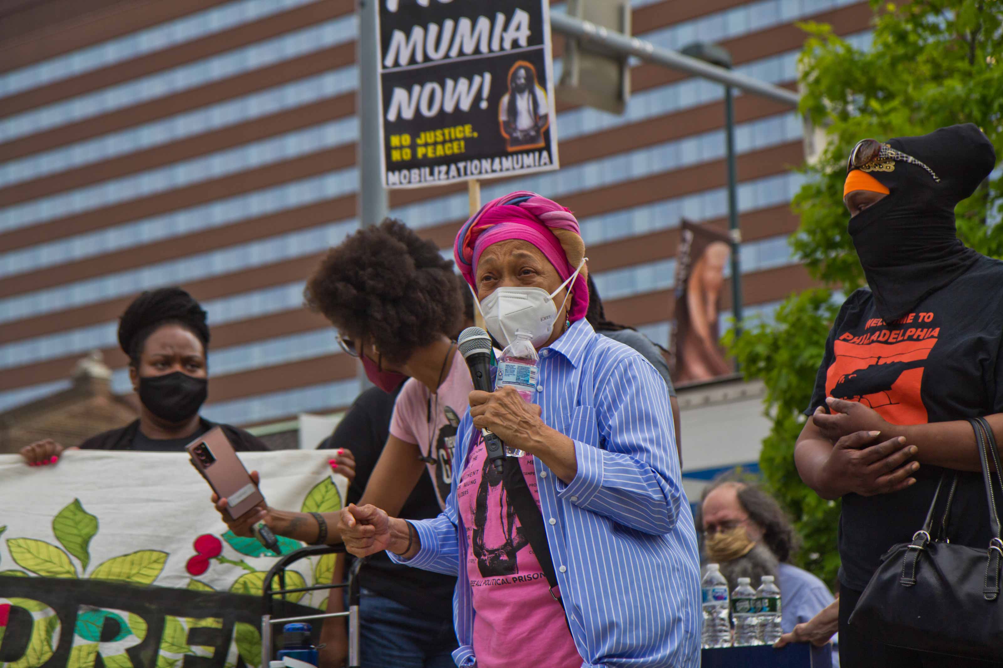 Pam Africa described police abuse her family experienced at a protest outside the Penn Museum on April 28, 2021, over the museum’s mistreatment of the remains of children Tree and Delisha Africa who were killed when Philadelphia police dropped explosives on MOVE's headquarters in 1985. (Kimberly Paynter/WHYY)