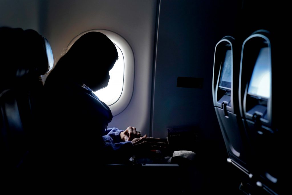 Virus Outbreak Vaccines Travel A passenger wears a face mask during an airline flight