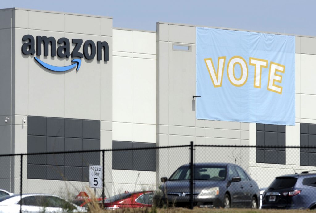 In this Tuesday, March 30, 2021 file photo, a banner encouraging workers to vote in labor balloting is shown at an Amazon warehouse in Bessemer, Ala.