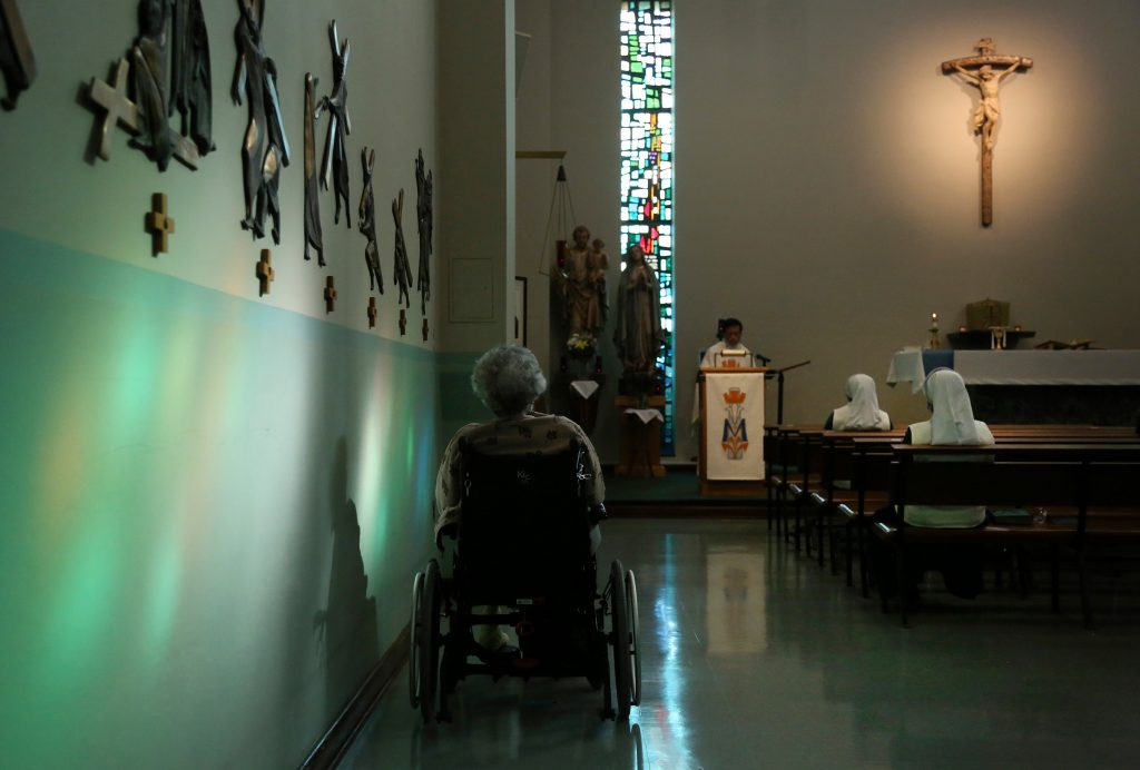 Virus Outbreak-Convents A resident of St. Anne Home sits bathed in sunlight streaming through a stained glass window during morning Mass attended by nuns and residents of the nursing facility in Greensburg, Pa., on Thursday, March 25, 2021. (AP Photo/Jessie Wardarski)