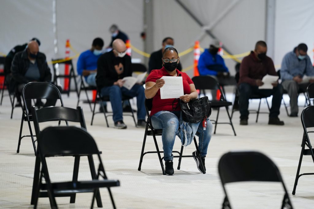 People sit in an observation area after being inoculated with the Johnson & Johnson COVID-19 vaccine