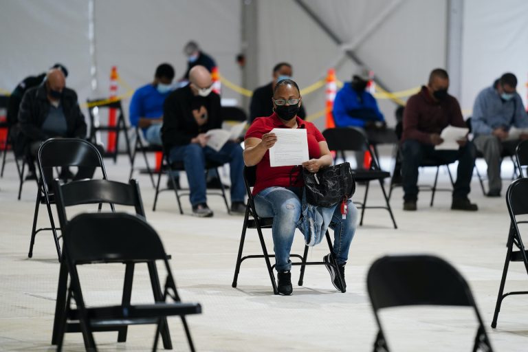 People sit in an observation area after being inoculated with the Johnson & Johnson COVID-19 vaccine