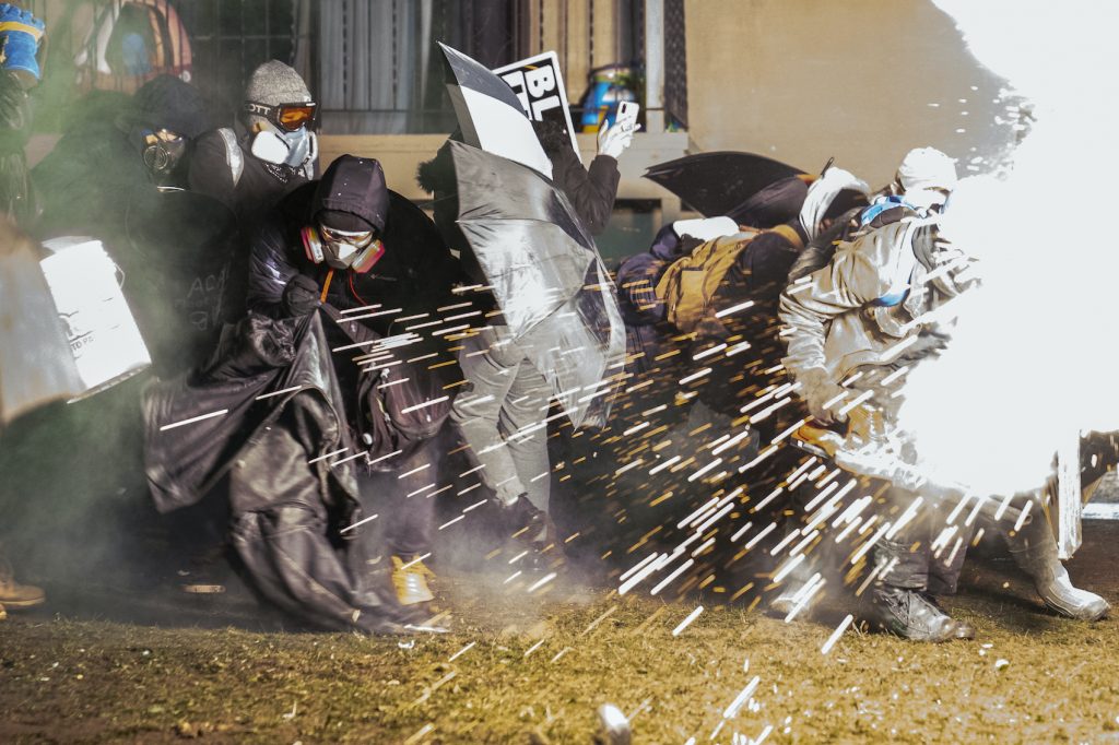 APTOPIX Police Shooting Minnesota Demonstrators take cover from crowd-dispersal munitions from police outside the Brooklyn Center Police Department to protest the shooting death of Daunte Wright, Tuesday, April 13, 2021, in Brooklyn Center, Minn. (AP Photo/John Minchillo)
