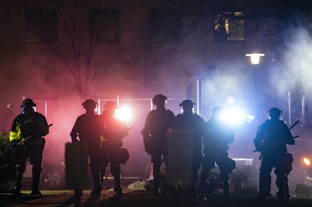 Law enforcement officers clear an area of demonstrators during a protest over Sunday's fatal police shooting of Daunte Wright
