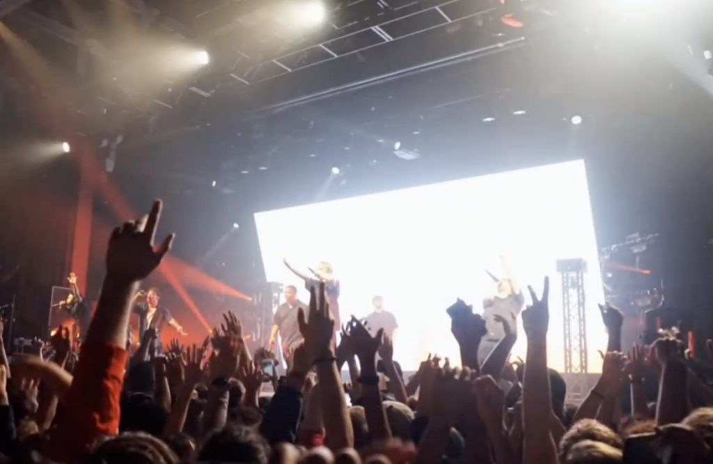 Concert goers raise their hands
