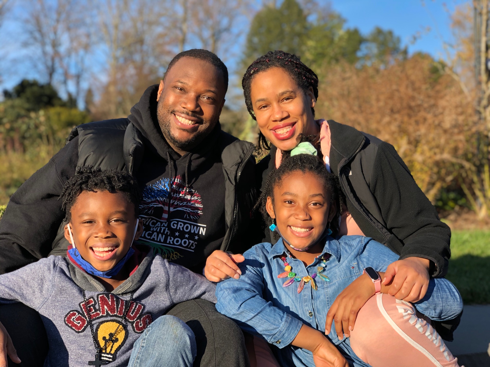 Psychologist George James sits with his family outside