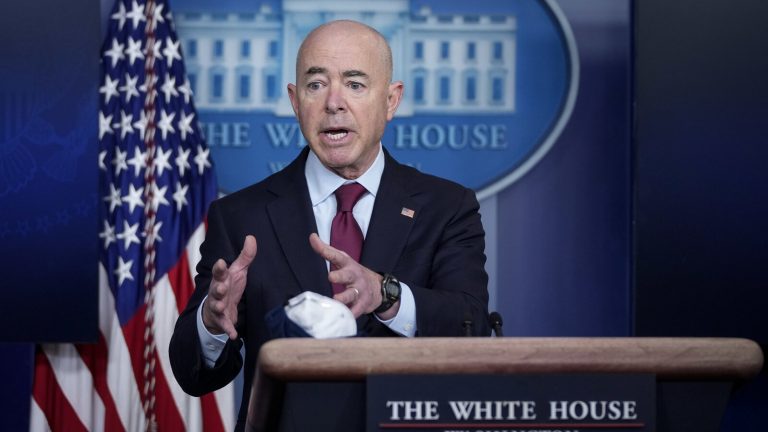Homeland Security Secretary Alejandro Mayorkas speaks from a podium at the White House