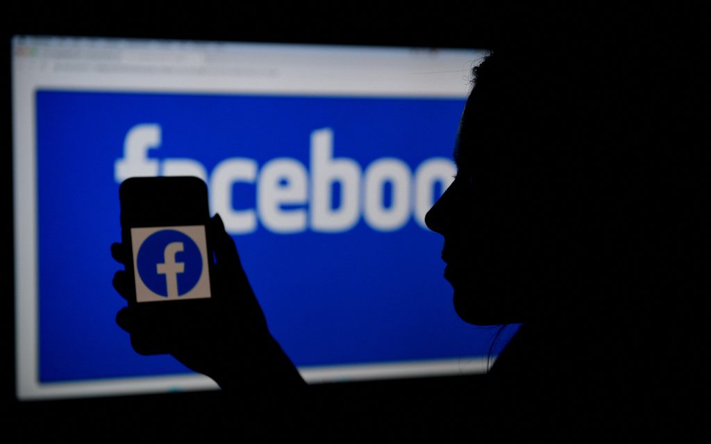 The leaked data includes personal information from 533 million Facebook users in106 countries. In this photo illustration, a smart phone screen displays the logo of Facebook on a Facebook website background