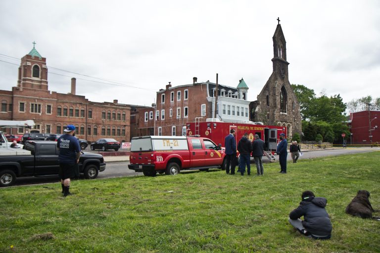 Neighbors in Philadelphia’s Tacony neighborhood watch workers at St. Leo the Great Roman Catholic Church the morning after a fire