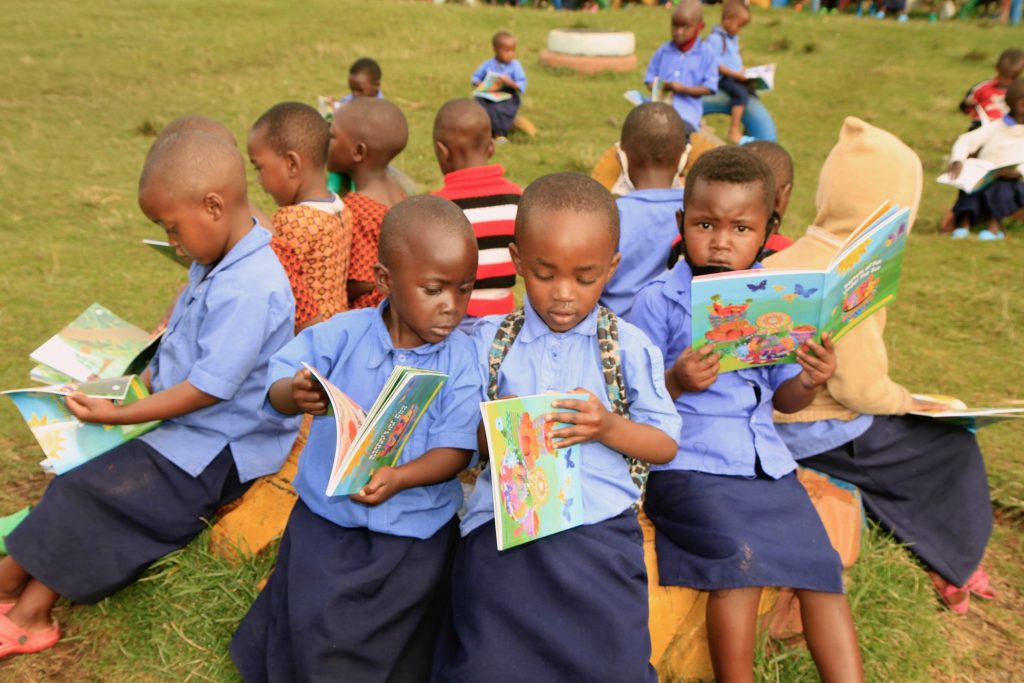 2021 05 18-provided-rwanda-preschoolers receive books girls read Preschoolers in Rwanda look at the books created for them by String Theory School students in Philadelphia. (Provided by String Theory Schools)