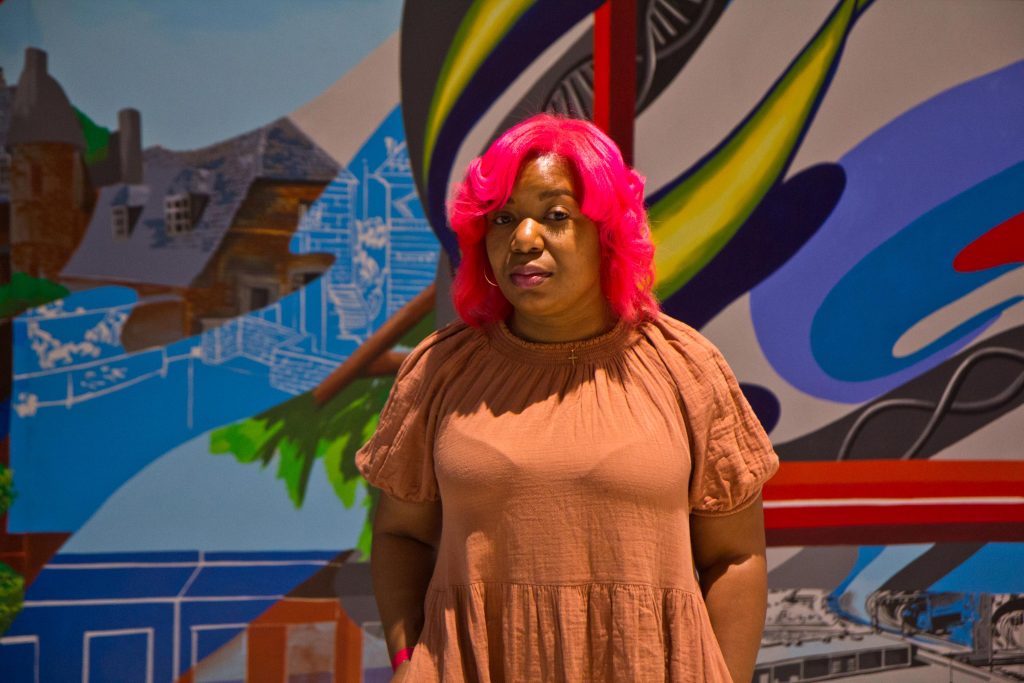 2021-05-5-k-paynter-the-path-mural-serena-saunders-3 Artist Serena Saunders with her mural 'The Path' at the Bulletin Building across from 30th Street Station in Philadelphia. (Kimberly Paynter/WHYY)