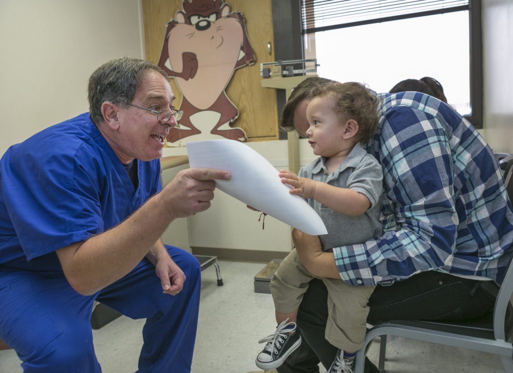 AP168236860848-1920×1396 Pediatrician Charles Goodman, left, talks to Frank Fierro, the father of 1 year-old Cameron Fierro. (AP Photo/Damian Dovarganes)