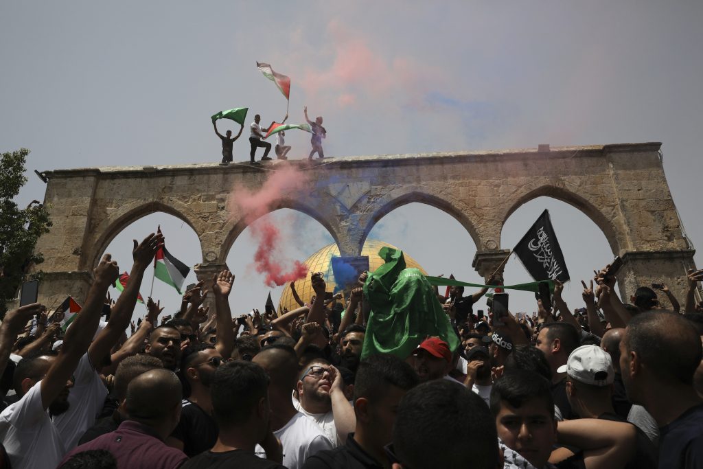 APTOPIX Israel Palestinians Palestinians wave national flags in front of the Dome of the Rock in the al-Aqsa mosque complex in Jerusalem, Friday, May 21, 202, as a cease-fire took effect between Hamas and Israel after an 11-day war. (AP Photo/Mahmoud Illean)