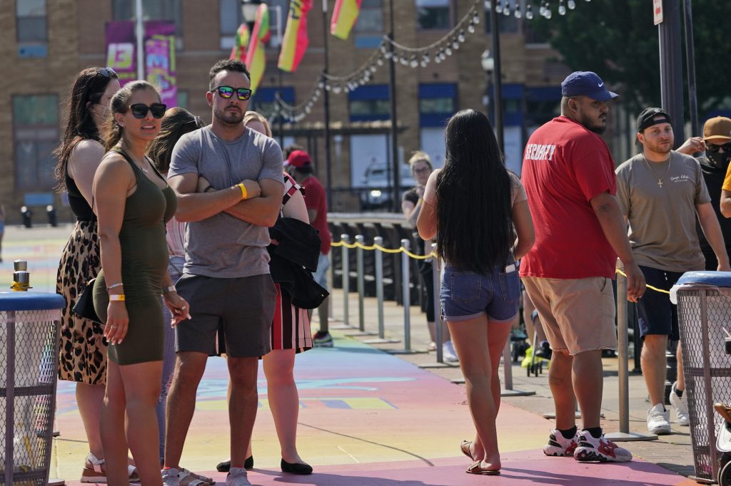 Virus Outbreak New Jersey People, some with masks and some without, wait in line to be seated outdoors on a pier