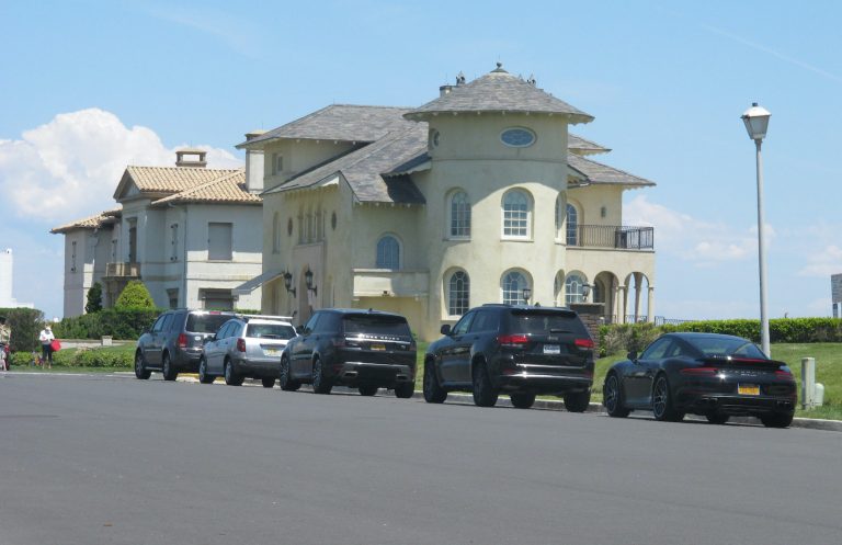 Cars are lined up on an oceanfront street in Deal