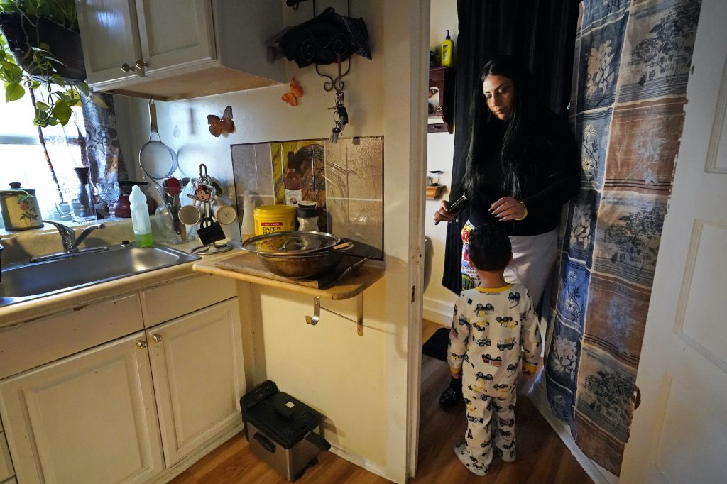 Isabel Miranda brushes the hair of her 4-year-old son, Julian, in their rental apartment