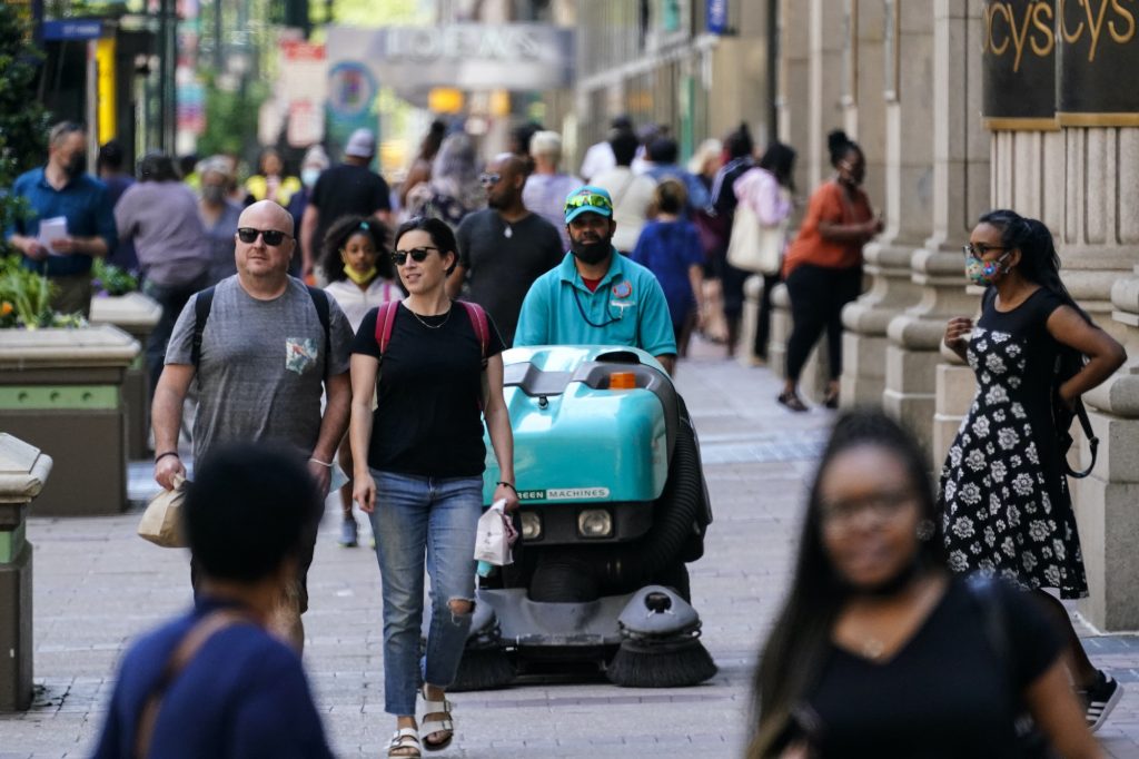 Virus Outbreak Pennsylvania People, some without masks, walk along Market Street