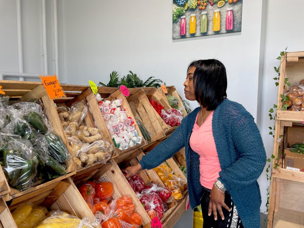 Adiyuh and the peppers Owner Adiyuh Davis inspects the pepper selection. (Cris Barrish/WHYY)