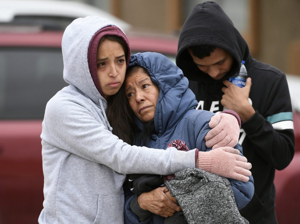 SHOOTING Family members hug each other on the street