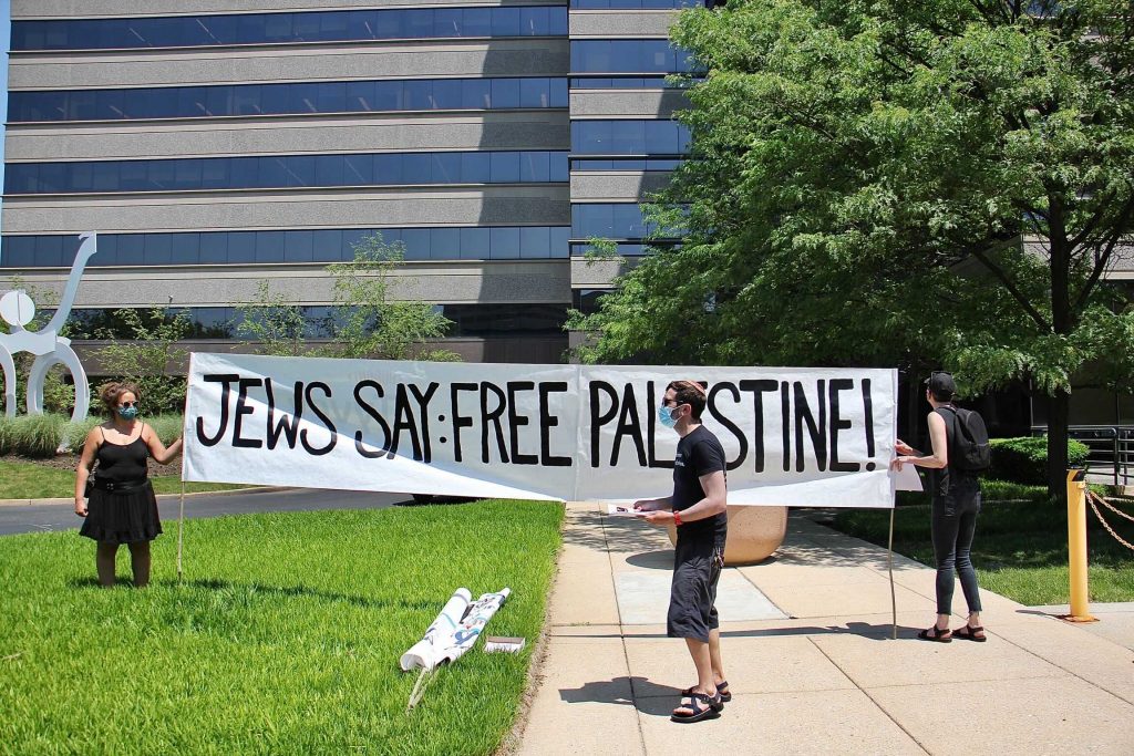 Image from iOS (102) Protesters unfurl a banner outside Susquehanna Investment Group in Bala Cynwyd while others stage a sit-in inside the building. The group asked to speak with Susquehanna’s wealthy founders about their support of the displacement of Palestinians by Israel. (Emma Lee/WHYY)