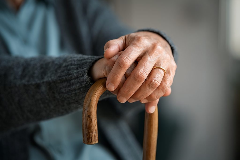 Close up of senior disabled woman hands holding walking stick. D (Rido81/BigStock)