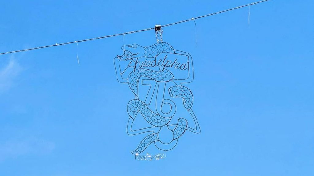 Reed Bmore's Sixers' street art hanging over 9th Street